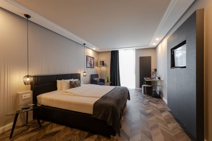 Hotelzimmer, in dem ein Bett in der Mitte steht und gedimmtes Licht