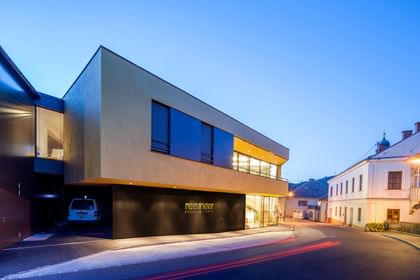 Modernes Gebäude der Bäckerei Reisinger in Gutau mit großzügigen Glasfronten und einer Fassadengestaltung mit CapaGold.