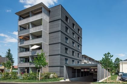 Wohngebäude von außen und Einfahrt in die Tiefgarage