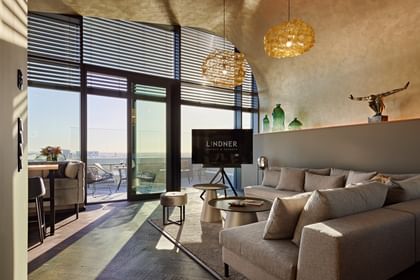 Graue Couch in einem gelb-goldenen Raum mit offener Terrassentür