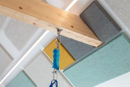 Blick auf den Holzbalken und die bunten Hanfakustik-Platten an der Decke