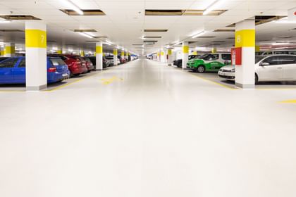Weiß-gelbe Säulen in der Parkgarage mit parkenden Autos