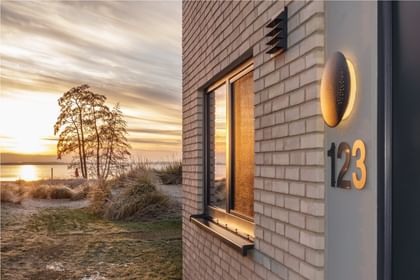Helles Klinkerhaus am See im Sonnenuntergang – ruhig, stimmungsvoll und naturnah