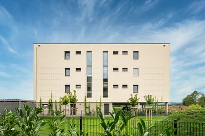 Außenansicht des Gebäudes mit grüner Rasenfläche vor dem Gebäude