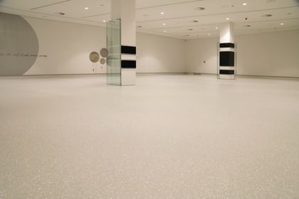 Moderner Ausstellungsraum mit weißen Wänden und Bodenbeschichtung im Schlossmuseum Linz