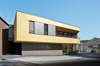 Modernes Gebäude der Bäckerei Reisinger in Gutau mit großzügigen Glasfronten und einer Fassadengestaltung mit CapaGold.