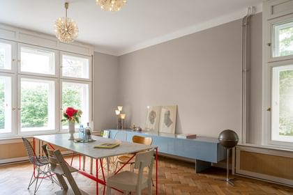 Esszimmer mit Tisch, sechs Stühlen und blauem Sideboard