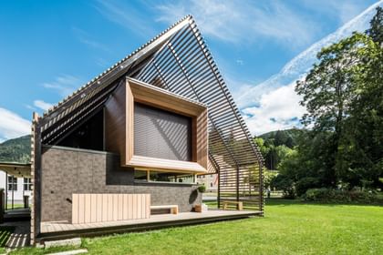 Außenansicht eines modernen Passivhauses mit Holzfassade in natürlichem Grauton, großen Fensterflächen und flach geneigtem Dach, aufgenommen bei Tageslicht im Rahmen der NÖ Landesausstellung in Neubruck, Scheibbs.