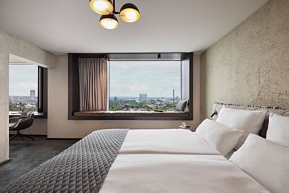 Hotelzimmer mit Doppelbett und Ausblick aus dem Fenster