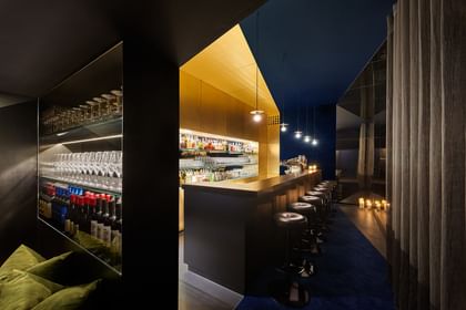 Goldene Bar im gedimmten Licht mit schwarzen Barhockern