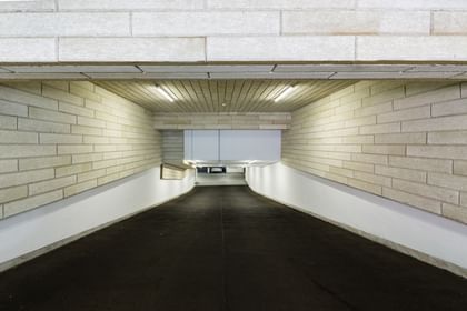 Tiefgarageneinfahrt mit Wänden in Ziegeloptik, schwarz Asphaltfläche