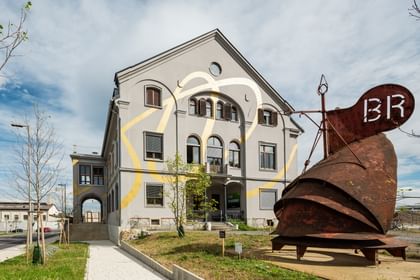 Gebäude mit Goldekoration und einer davorstehenden rostigen Stahlkonstruktion
