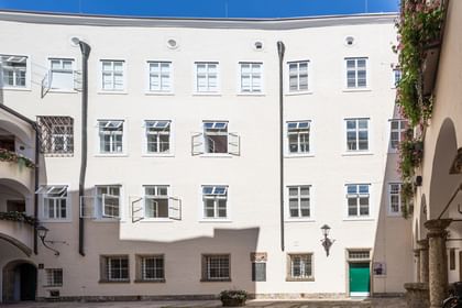 Von der Sonne angestrahlte Außenfassade mit geöffneten Fenstern
