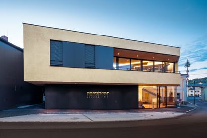 Modernes Gebäude der Bäckerei Reisinger in Gutau mit großzügigen Glasfronten und einer Fassadengestaltung mit CapaGold.