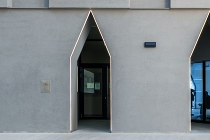 Naufnahme Fassade mit großen, schmalen Eingangstüren, die in einer einzigartigen, spitz zulaufenden Form angeordnet sind