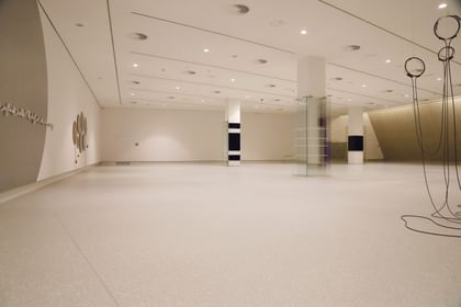 Moderner Ausstellungsraum mit weißen Wänden und Bodenbeschichtung im Schlossmuseum Linz