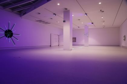 Moderner Ausstellungsraum mit weißen Wänden und Bodenbeschichtung im Schlossmuseum Linz