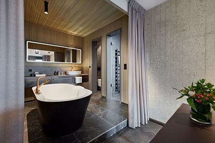 Schwarze Badewanne inmitten eines Hotel-Badezimmers