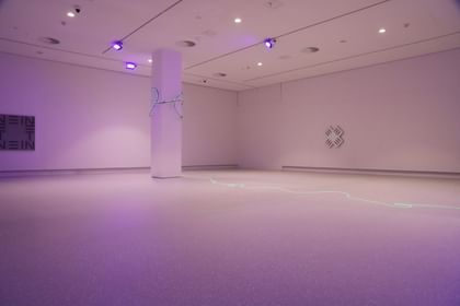 Moderner Ausstellungsraum mit weißen Wänden und Bodenbeschichtung im Schlossmuseum Linz