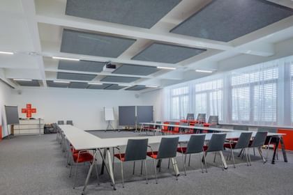 Seminarraum mit schlichten grauen Akustikpaneelen aus Hanf an der Decke, ruhig und funktional