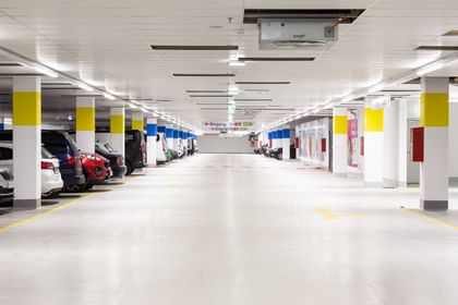 Parkgarage mit parkenden Autos und Eingang-Beschilderung