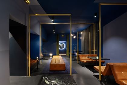 Lounge mit blauen Wänden, braunen Sesseln und goldenen Wandelementen
