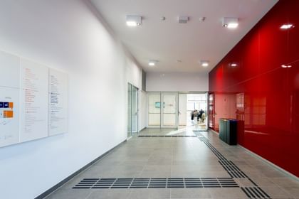 Langer, lichtdurchfluteter Flur mit weißen Wänden und großen Glasflächen im modernen Gebäude der Wirtschaftsuniversität Wien.