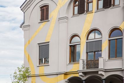 Gold-verzierte Fassade mit rechteckigen und Bogenfenstern