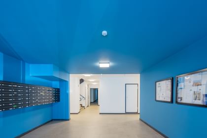 Eingangsbereich Mehrparteienhaus, blaue Wände, Briefkästen