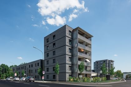 Wohngebäude von außen mit davorstehenden parkenden Autos