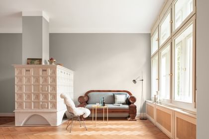 Antike Couch neben einem weißen Kaminofen