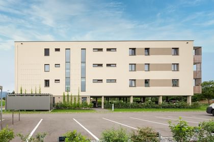 Außenansicht des Gebäudes mit Parkplätzen im Vordergrund