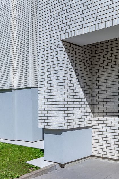 Elegante weiße Klinkerstruktur mit präzisem Fugenspiel und markanter Schattenwirkung