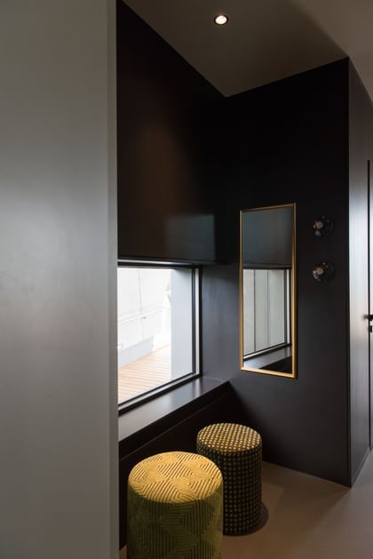 Schwarze Ecke im Restaurant mit Spiegel und goldenen Sitzhockern