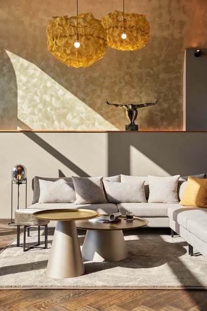 Graue Couch mit beige-grauen Beistelltischen
