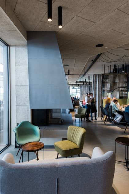 Innenraum des Restaurants mit grauer Couch und zwei Sesseln 