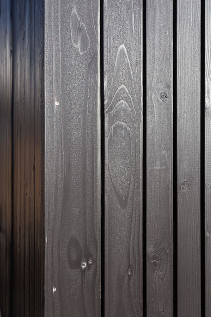 Nahaufnahme der dunklen Holzfassade des Wohngebäudes