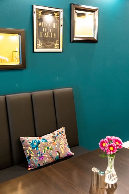 Braune Sitzbank mit braunem Tisch vor einer blauen Wand