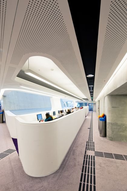 Offener, lichtdurchfluteter Bibliotheksbereich der Wirtschaftsuniversität Wien mit modernen weißen Wänden, großen Fensterflächen und freien Arbeitsplätzen.