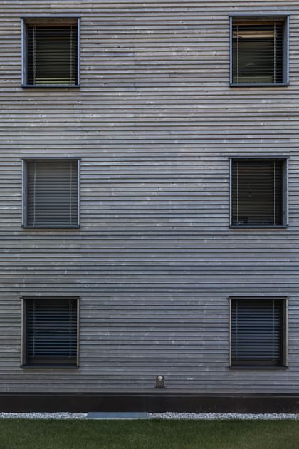 Holzfassade des Gebäudes mit sechs Fenstern