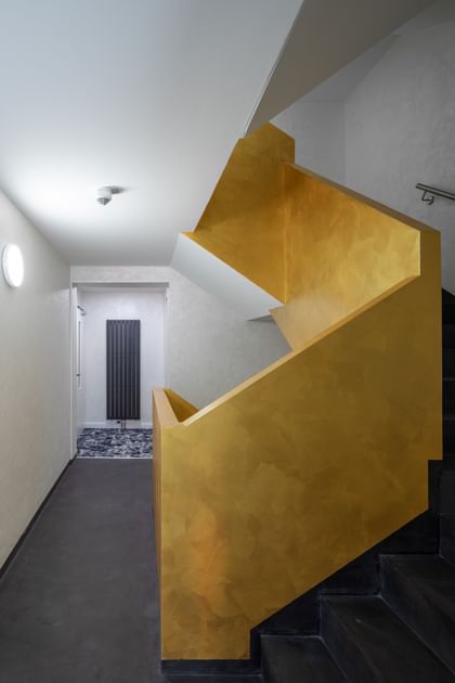 Treppenaufgang mit schwarzen Treppen und einem gelben Geländer