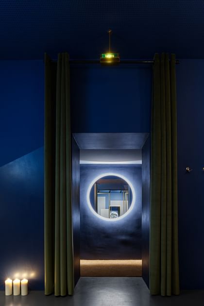 Blauer Raum mit beleuchtetem runden Spiegel