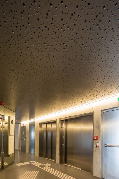 Minimalistischer, heller Korridor im Erdgeschoss der Wirtschaftsuniversität Wien mit Aufzügen und Beleuchtungselemente