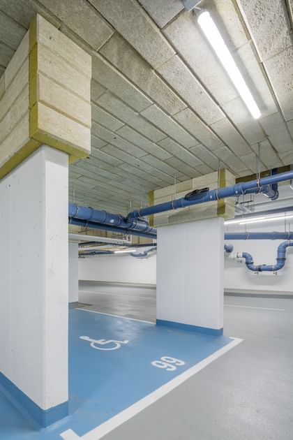 Tiefgarage mit weißen Säulen und blauen Parkflächen