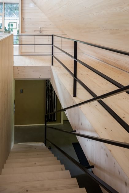 Modernes Treppenhaus aus Holz mit schwarzem Geländer im Passivhaus Scheibbs Neubruck, nachhaltige Architektur, Niederösterreich Landesausstellung