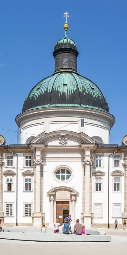 Kajetanerkirche mit spazierenden Menschen im Vordergrund