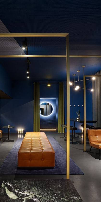 Lounge mit blauen Wänden, braunen Sesseln und goldenen Wandelementen