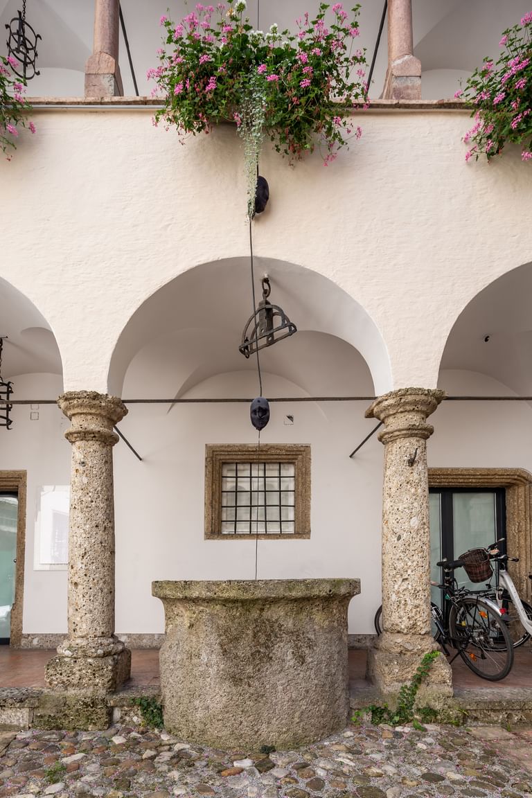 Alter Brunnen zwischen zwei Tragesäulen des Gebäudes