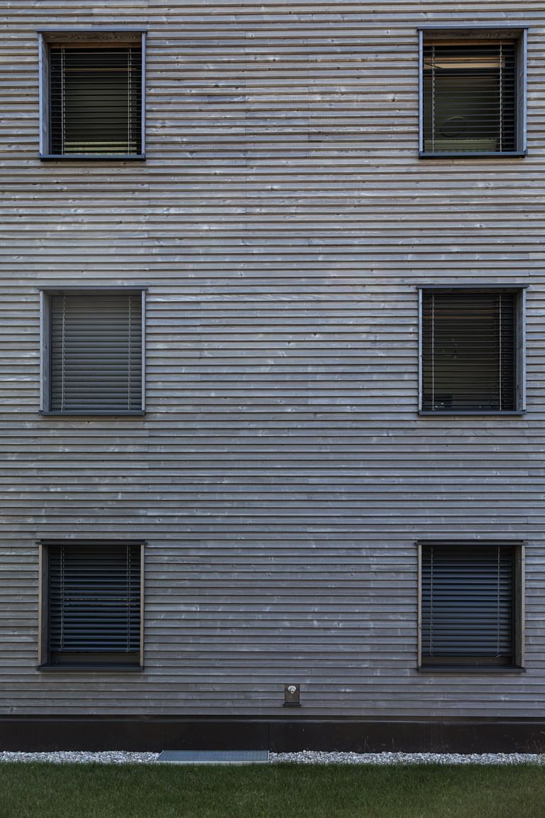 Holzfassade des Gebäudes mit sechs Fenstern