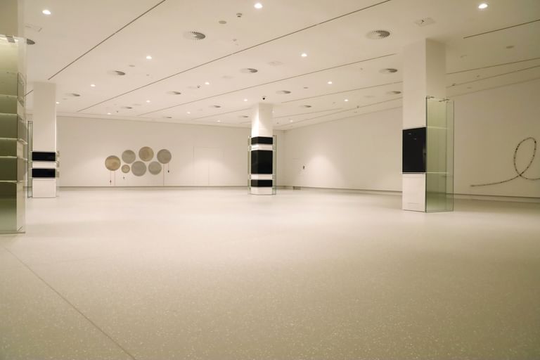 Moderner Ausstellungsraum mit weißen Wänden und Bodenbeschichtung im Schlossmuseum Linz